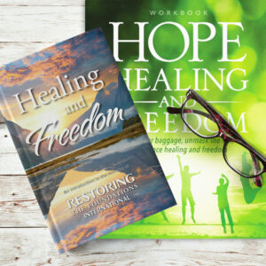 Healing and Freedom book on top of hope healing and freedom workbook with glasses